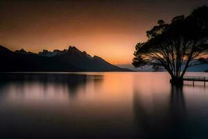 un' albero sta su il riva di un' lago a tramonto. ai-generato foto