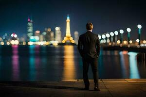 un' uomo nel un' completo da uomo sta di il acqua guardare a il città a notte. ai-generato foto