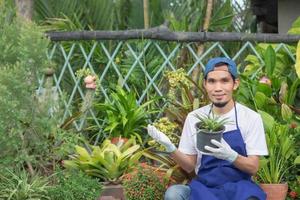 l'uomo vende il giardino delle piante in negozio foto