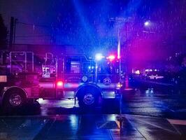 portland, Oregon, Stati Uniti d'America - 11.02.2023 fuoco camion con lampeggiante luci a notte, chiamato per un' fuoco allarme nel il platetown la zona. pioggia. foto