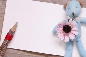 matita di legno schizzo vuoto carta bianca orso blu bambola fiore viola foto