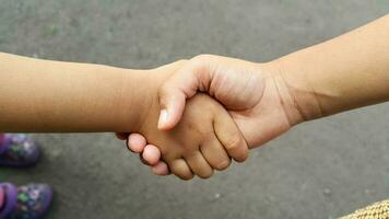 vicino su Visualizza di bambini stretta di mano. Due figli di mani Tenere ogni Altro. foto