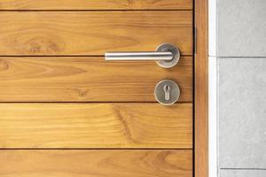 maniglia della porta in acciaio inossidabile e porta in legno foto