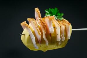 crudo patate preparato per cottura al forno, con lardo su nero sfondo foto