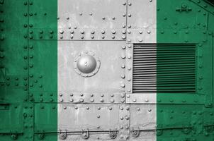 Nigeria bandiera raffigurato su lato parte di militare blindato serbatoio avvicinamento. esercito forze concettuale sfondo foto