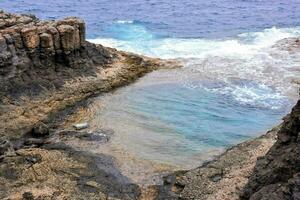 un' piscina di acqua nel il mezzo di un' roccioso scogliera foto