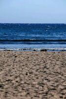 un' spiaggia con un' grande corpo di acqua nel il sfondo foto