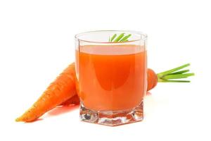 succo di carota in un bicchiere trasparente con carote da dietro foto