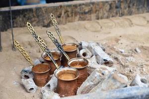 cucinare il caffè turco sulla sabbia foto