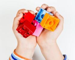 le mani dei bambini tengono parti di lego foto