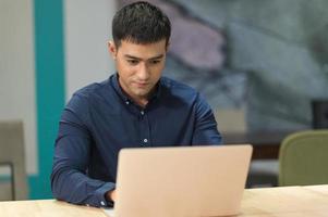 giovane uomo d'affari asiatico che lavora con il computer portatile in ufficio. foto