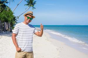 giovanotto felice sulla spiaggia tropicale foto