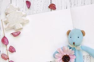 tavolo in legno dipinto di bianco petali di fiori orso bambola albero di natale artigianale foto