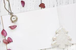 carta con albero di natale bianco, petali e un orologio foto