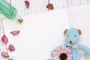 carta con giocattolo, fiore, petali e bottiglia foto