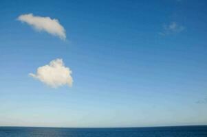 un' blu cielo con nuvole nel il distanza foto