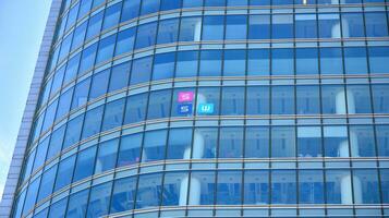 bicchiere facciata di il edifici con un' blu cielo. grattacieli nel il attività commerciale città centro.. sfondo di moderno bicchiere edifici. foto