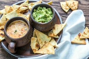 ciotole di guacamole e queso con tortilla chips foto