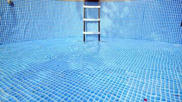 acqua fluente a partire dal il tubo flessibile in il piscina Riempimento. il dentro di il nuoto piscina. foto