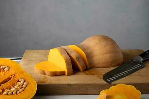 maturo zucca tagliare in su un' di legno taglio tavola per cucinando. selettivo Fokus foto