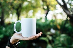 tazza bianca a portata di mano in tempo di relax foto