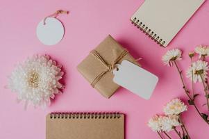 confezione regalo, fiore e un libro su sfondo rosa foto