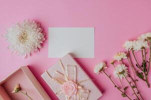 confezione regalo rosa, fiore e carta bianca su sfondo rosa foto
