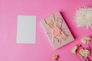 confezione regalo rosa, fiore e carta bianca su sfondo rosa foto