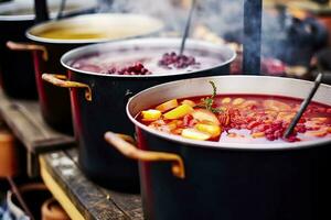 bevande frutta e frutti di bosco caldo vin brulé vino nel pentole con vapore nel strada cibo mercato. generativo ai foto