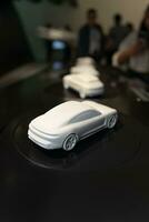 un' miniatura modello di un' porsche macchina. bianca auto Modelli siamo visualizzato come mostre quello persone Guarda a. foto