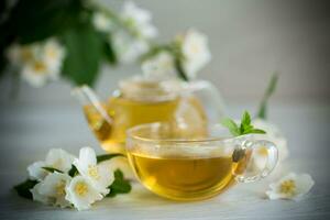 composizione con tazza di gelsomino tè e fiori foto