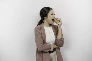 Affamato asiatico donna dipendente è contento di spuntini mela, bocca mordere salutare cibo per dieta e biologico stile di vita, isolato di bianca sfondo foto