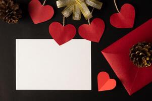 carta bianca e carta cuore rosso incollata su sfondo nero. foto