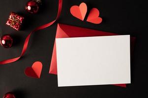 carta bianca e carta cuore rosso incollata su sfondo nero. foto