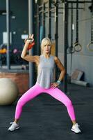 in forma giovane donna occupazione con kettlebell nel fitness club foto