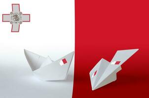 Malta bandiera raffigurato su carta origami aereo e barca. fatto a mano arti concetto foto