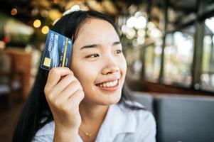 donna sorridente che tiene la carta di credito foto