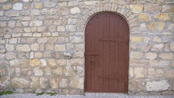 muro di mattoni di pietra vintage retrò e sfondo di una vecchia porta di legno foto