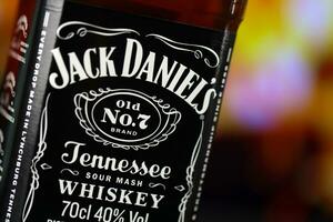 kiev, Ucraina - Maggio 4, 2022 Jack daniel originale alcool bottiglia su di legno tavolo con rosso camino foto