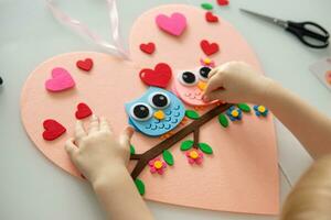 un' blogger ragazza fa un' provato mestiere per San Valentino giorno nel il forma di un' cuore. il concetto di figli di creatività e fatto a mano. foto