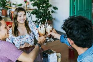 tre sorridente migliore amici incontro e tostatura nel un' caffè negozio, contento giovane amici tostatura nel un' caffè negozio. contento amici godendo un' frappè nel un' caffè negozio foto