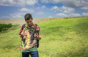 allegro tipo assunzione un' foto nel il campo, giovane uomo assunzione fotografie nel il campo con il suo cellula Telefono