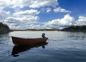 piccolo di legno barca nel il mezzo di un' lago, solitario di legno barca nel il acqua, isolato di legno barca, superiore Visualizza di un' bianca piccolo di legno barca galleggiante nel il mezzo di un' lago foto