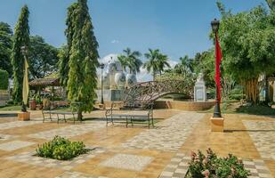 un' simpatico e rilassato parco con un' di legno ponte al di sopra di un' acqua Fontana, tradizionale parco di Nagarote, Nicaragua. Visualizza di un' calma parco con un' piccolo di legno ponte su un' soleggiato giorno. nagarote centrale parco foto