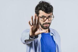 grave giovane uomo fermare cartello con palma, caucasico uomo fermare cartello con mano, fermare concetto con mano foto