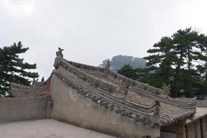Tetto con scultura in pietra nella sacra montagna taoista del monte huashan in Cina foto