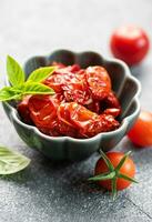 ciotola con sole secco pomodori con fresco erbe aromatiche e spezie. foto