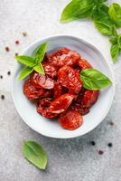 ciotola con sole secco pomodori con fresco erbe aromatiche e spezie. foto