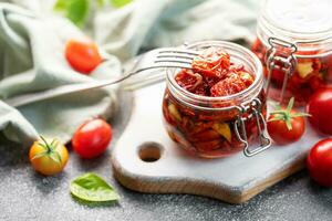 barattoli con sole secco pomodori con fresco erbe aromatiche e spezie. foto