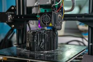 un' 3d stampante stampe un' nero modello. tecnologia a casa foto